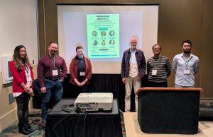 Presenters at the MERIC symposium at MAS standing in front of the event room.
