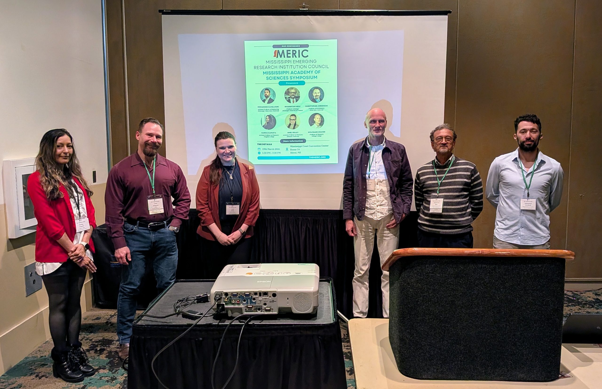 Presenters at the MERIC symposium at MAS standing in front of the event room.